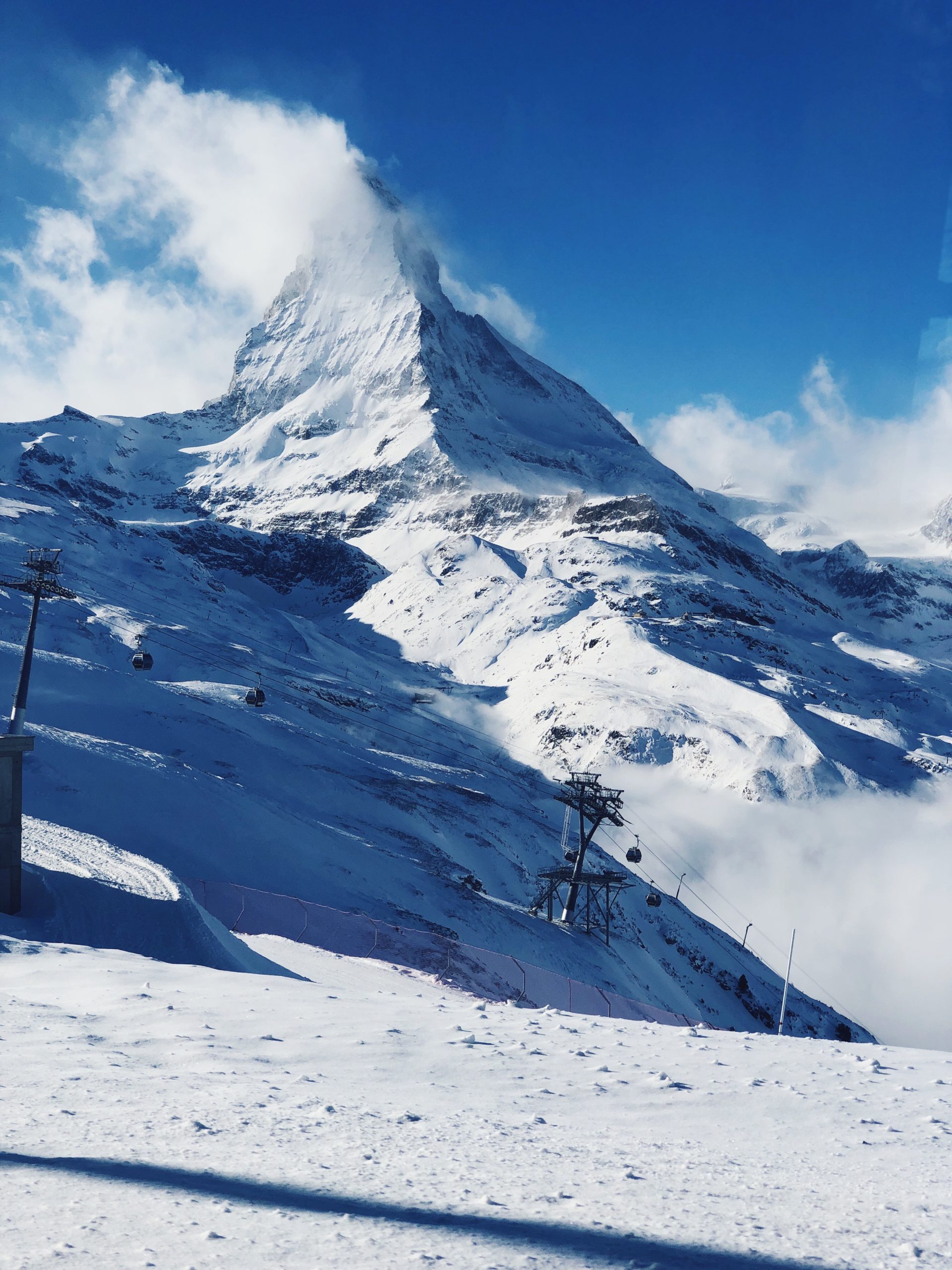 View of the Matterhorn towering over the alpine village of Zermatt with snow-covered rooftops in winter